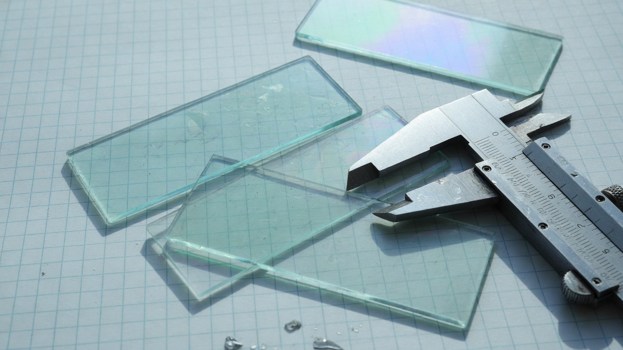 Glass microscope slides in a steel tray on mint graph paper